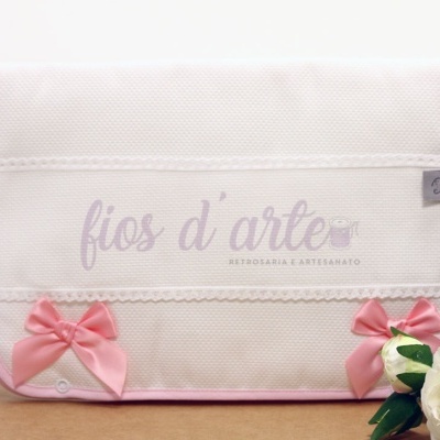 Estojo branco com laços de cetim rosa e texto 'fios d'arte' em lilás