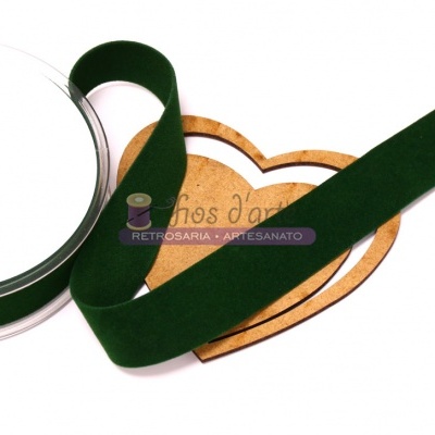 Fita de veludo verde escuro sobre base de madeira em forma de coração com texto visível