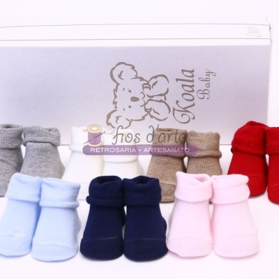 Cinco pares de peúgas para bebé em várias cores com caixa branca 'Koala Baby' ao fundo