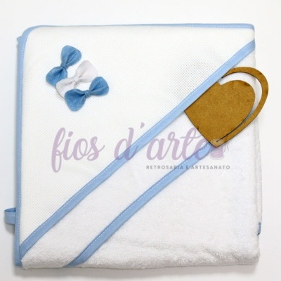 Fralda de banho branca com bordas azuis e laços decorativos azuis e brancos