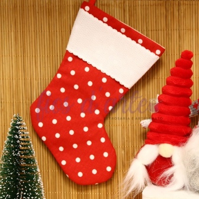 Meia de Natal vermelha com bolinhas brancas decorativa entre duas figuras de Natal