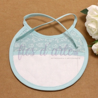 Babete redonda azul claro com padrão branco e fitas para amarrar