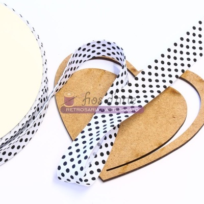 Fita branca com bolas pretas sobre cartão castanho