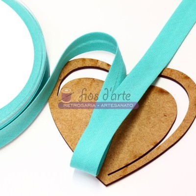 Fita azul turquesa sobre base de cartão em forma de coração com etiqueta de artesanato