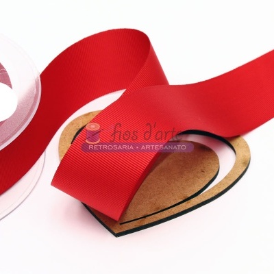 Fita de tecido vermelha enrolada numa bobina plástica