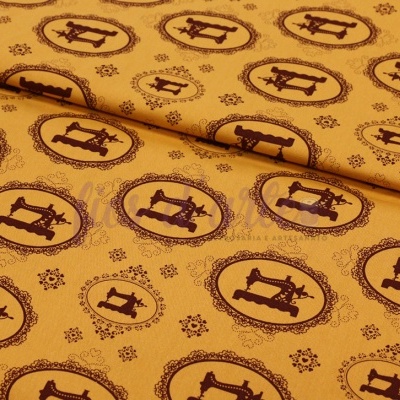 Tecido amarelo com padrão de máquinas de costura castanhas em oval.