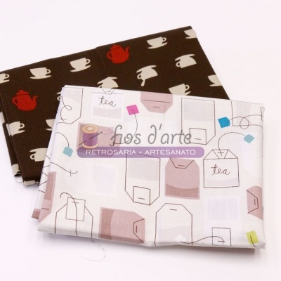 Duas toalhas de tecido com padrões de chá dobradas sobre fundo branco