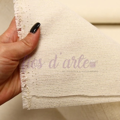 Tecido cru de algodão com textura rugosa segurado por mão com unhas pretas