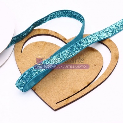 Fita azul glitter enrolada em carretel sobre coração de madeira