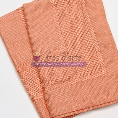 Toalha cor de salmão com padrão em relevo e texto impresso