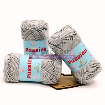 três novelos de lã cinzenta clara com rótulos azuis e texto 'Passion'