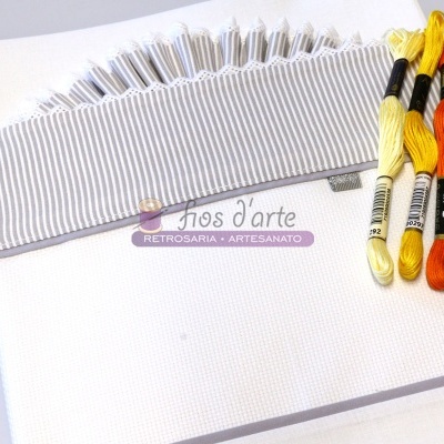 tecido branco de bordado com fita riscada e novelos de linha colorida