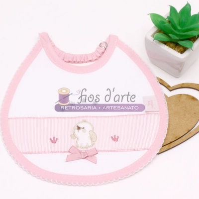 Babete branco e rosa com bordado de cão e planta artificial em vaso branco