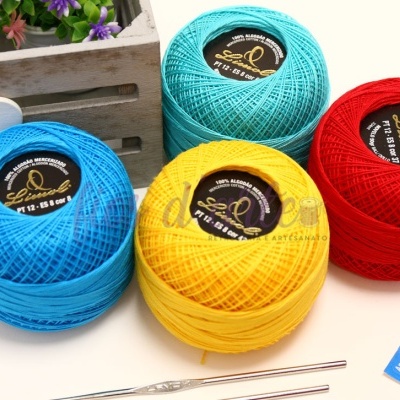 Novelos de linha de algodão de várias cores com etiquetas e gancho de crochê