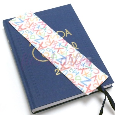 Marcador de livro de tecido branco com letras coloridas sobre agenda azul 2022