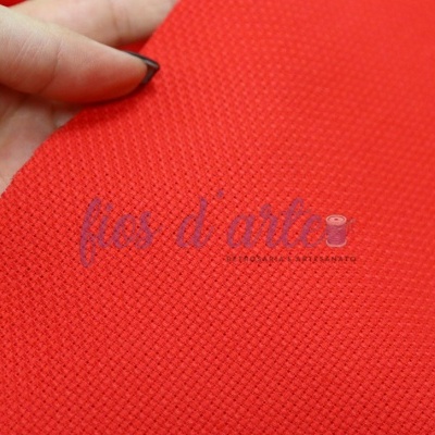 Tecido vermelho de malha segurado por mão com unha preta com texto impresso