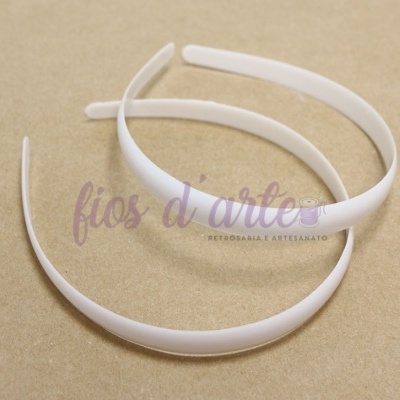 Duas tiaras brancas de plástico sobre superfície bege com texto 'fios d'arte'