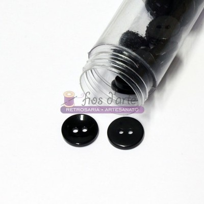 Frasco de botões pretos redondos com dois furos, dois botões fora do frasco em superfície branca.