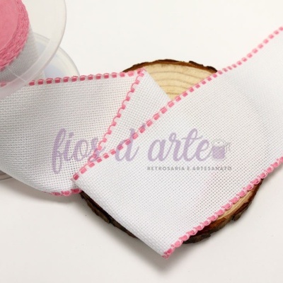 Fita decorativa branca com bordas rosas sobre disco de madeira e fundo branco