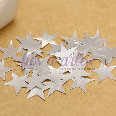 Estrelas decorativas prateadas em superfície bege