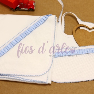 Toalha de banho branca com borda azul e babete branco com borda azul para bebé