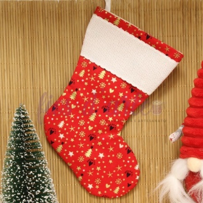 Meia de Natal vermelha decorada com padrão dourado, árvore de Natal e gnomos em fundo de madeira