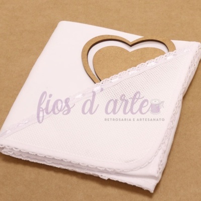 Guardanapo branco com borda de renda em suporte de madeira em forma de coração