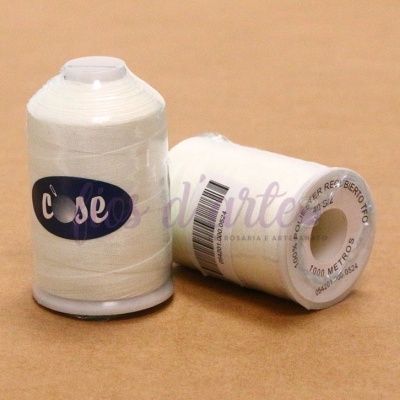 Dois rolos de linha de costura branca com rótulo 'case' sobre superfície castanha