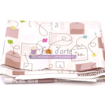 Pano de tecido dobrado com padrão colorido de sacos de chá e a palavra Tea