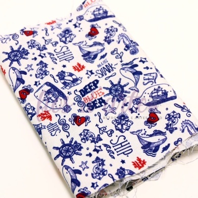 Tecido dobrado com padrão náutico azul e vermelho sobre fundo branco