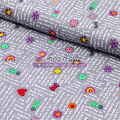 Tecido cinzento com textos brancos e pequenos símbolos coloridos como corações, arco-íris e flores