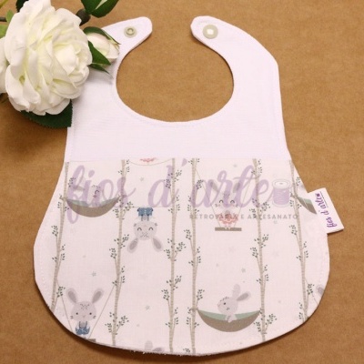 Babete branco com padrão de coelhos e ramos verdes