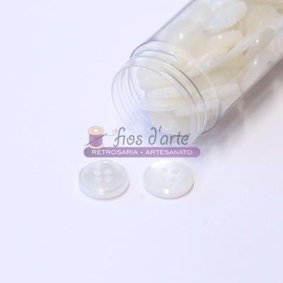 Frasco com botões brancos ovais de plástico em fundo branco