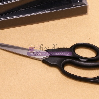 Tesoura com punho preto e lâminas metálicas sobre superfície bege