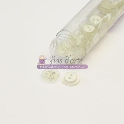 Botões brancos de diversos tamanhos dentro de um tubo transparente
