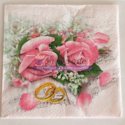 Guardanapo decorado com rosas cor-de-rosa, folhas, alianças douradas e notas musicais