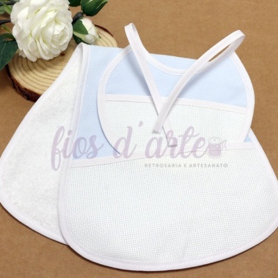 dois babetes para bebé em tecido branco e azul com acabamento branco