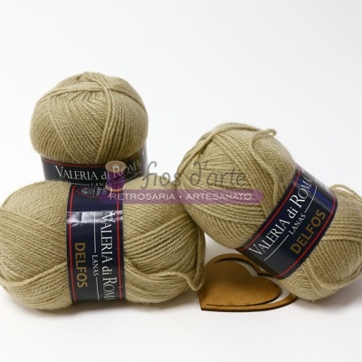 Três novelos de lã bege claro da marca VALERIA DI ROMA colecção DELFOS em fundo branco