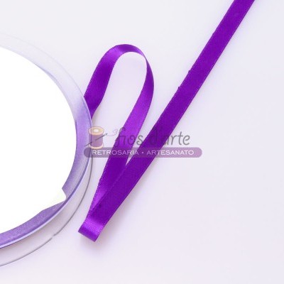 Fita roxa acetinada fina desenrolada sobre fundo branco