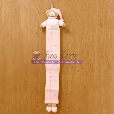 Medidor de altura infantil cor de rosa com boneco sorridente e parede de madeira