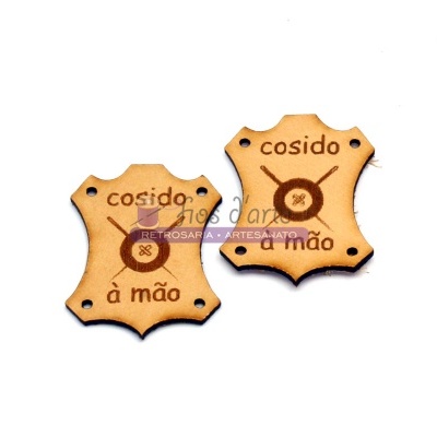 Etiquetas de pele castanha com texto 'cosido à mão' e símbolo circular com agulhas