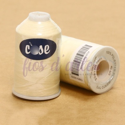 Cones de linha de costura bege com etiquetas e código de barras sobre fundo bege