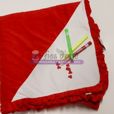 Manta vermelha e branca com babados e marcadores coloridos sobre a manta