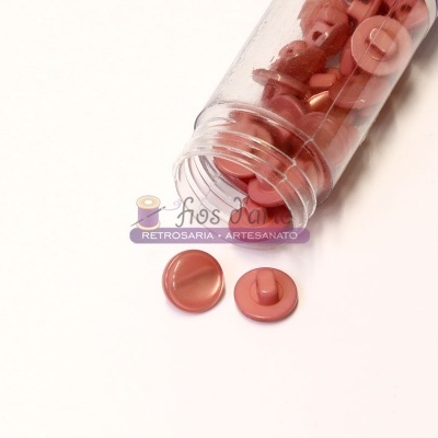 Frasco com botões vermelhos de plástico e dois botões fora do frasco