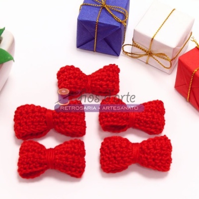 Cinco laços vermelhos de lã tricotada com presentes coloridos e planta em vaso branco