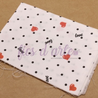 Tecido branco com bolinhas pretas, corações vermelhos e palavra love em preto