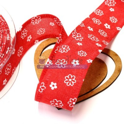 Fita vermelha com flores brancas enrolada em carretel