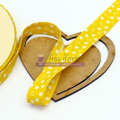 Fita decorativa amarela com estrelas brancas sobre base de madeira coração