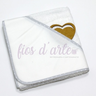 Toalha branca com borda cinza de estrelas e corações de madeira em cima.