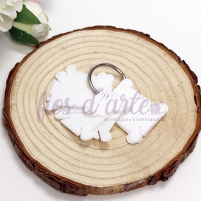 Chaveiro branco em forma de folhas sobre círculo de madeira